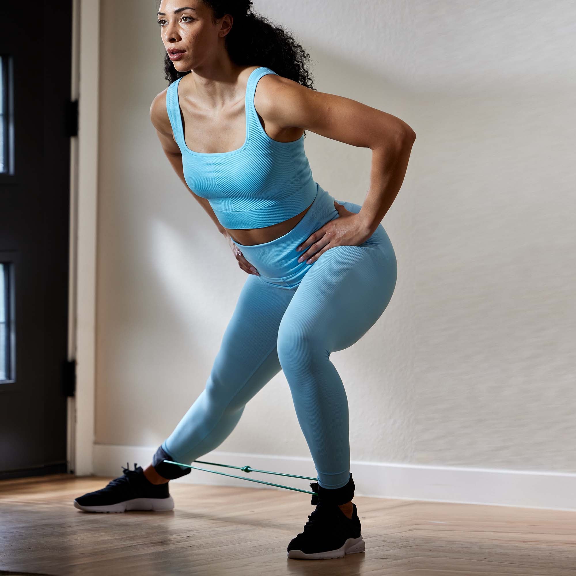 Person doing a Side Lunge while wearing the Xercuff 